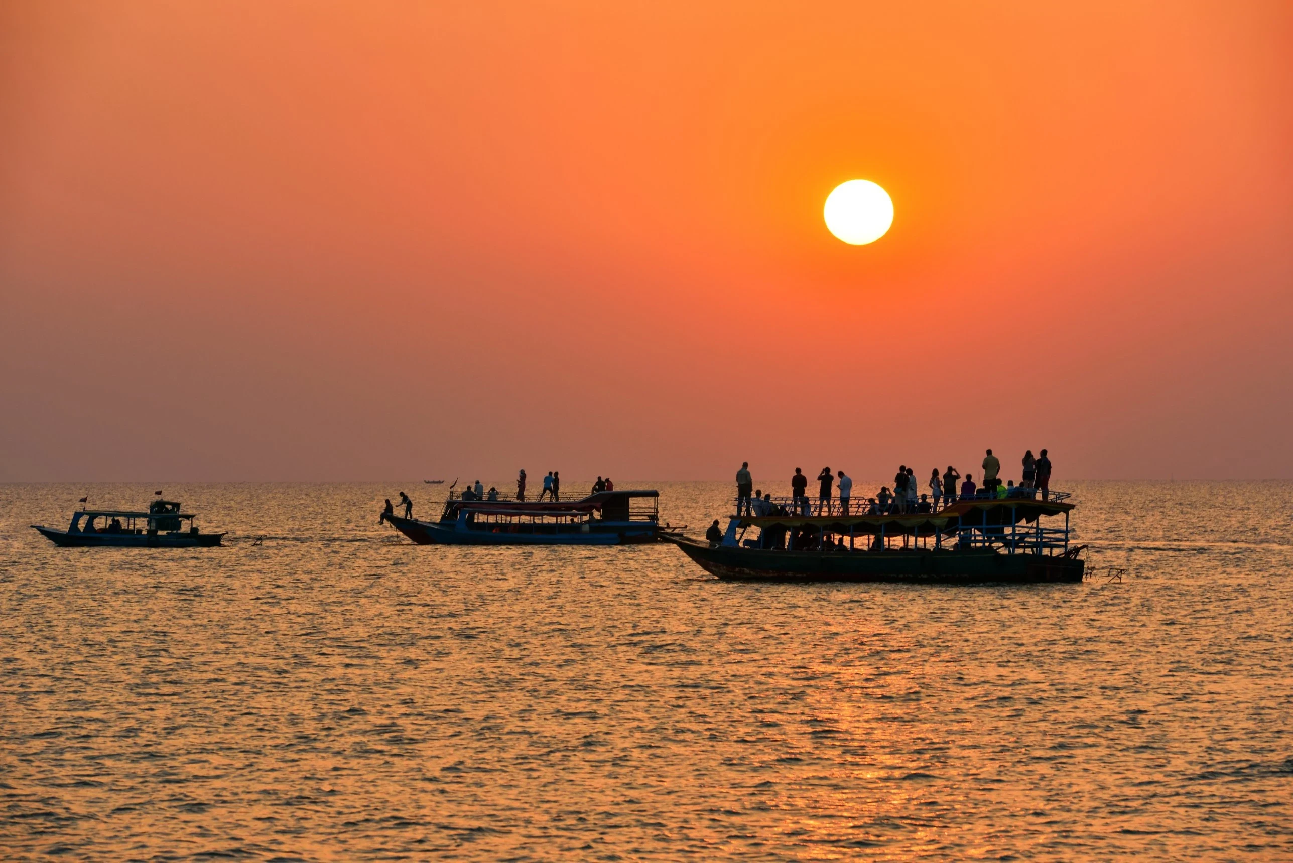 Boats watching the sunset on the open water of Tonle Sap Lake