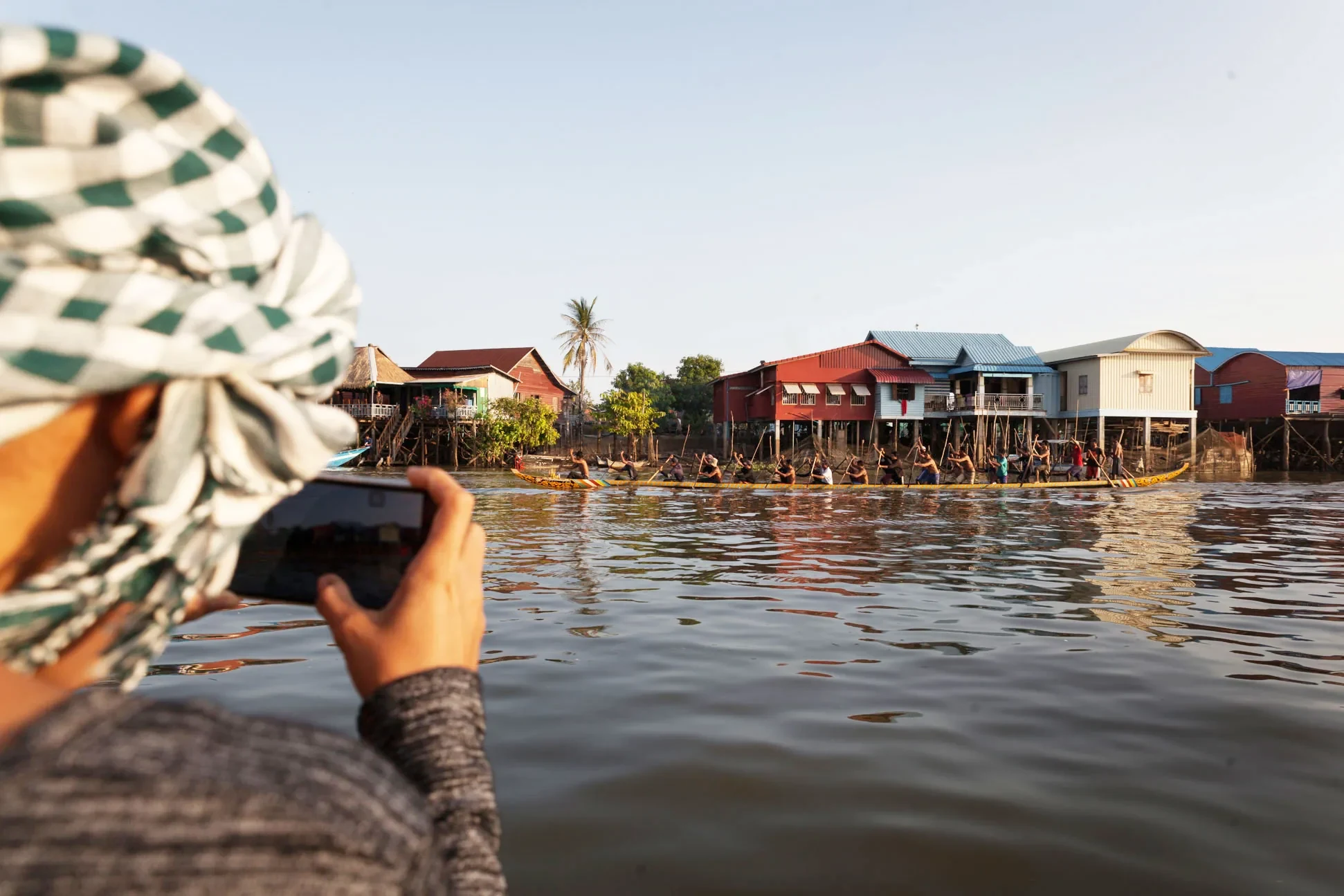 A guest photographing the stilt village from the boat